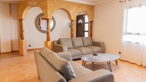 Un salon avec un canapé, une table basse et une cheminée en pierre.