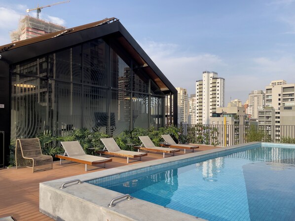 室外游泳池，池畔遮阳伞，日光浴躺椅