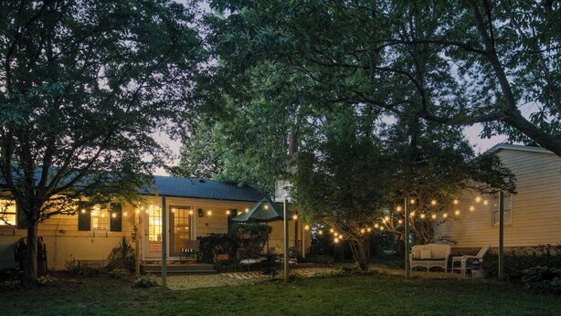 A house with a covered porch, string lights, and a lawn. - Charming Cottage - Near I-75 & Horse Park + Farms (Lexington)
