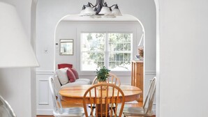 A dining area with a round wooden table, four chairs, and a chandelier. - Charming Cottage - Near I-75 & Horse Park + Farms (Lexington)