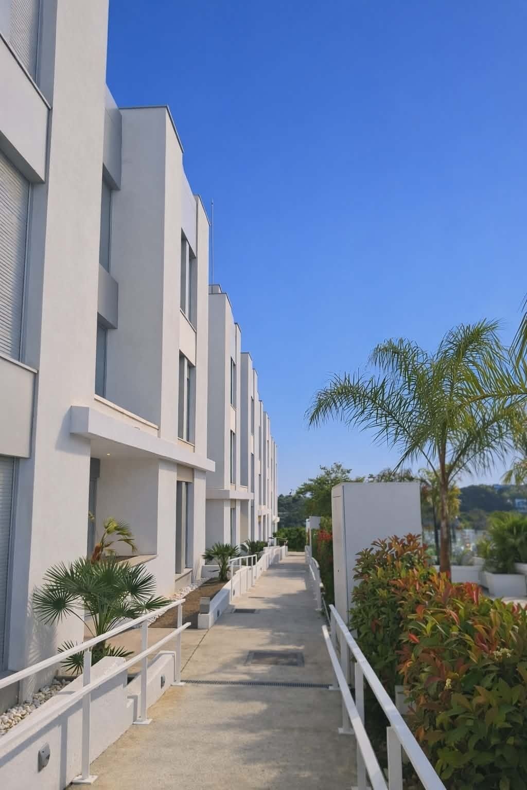 Ein modernes Gebäude mit gerader Fassade, zahlreichen Fenstern und blauem Himmel.