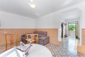 Et moderne interiør med sofa, stole, et bord og et mønstret gulv.
