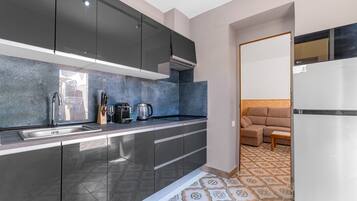 A modern kitchen with a built-in oven, a sink, and a coffee maker.