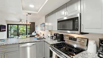 A modern kitchen with stainless steel appliances, granite countertops, and a view of the outdoors.