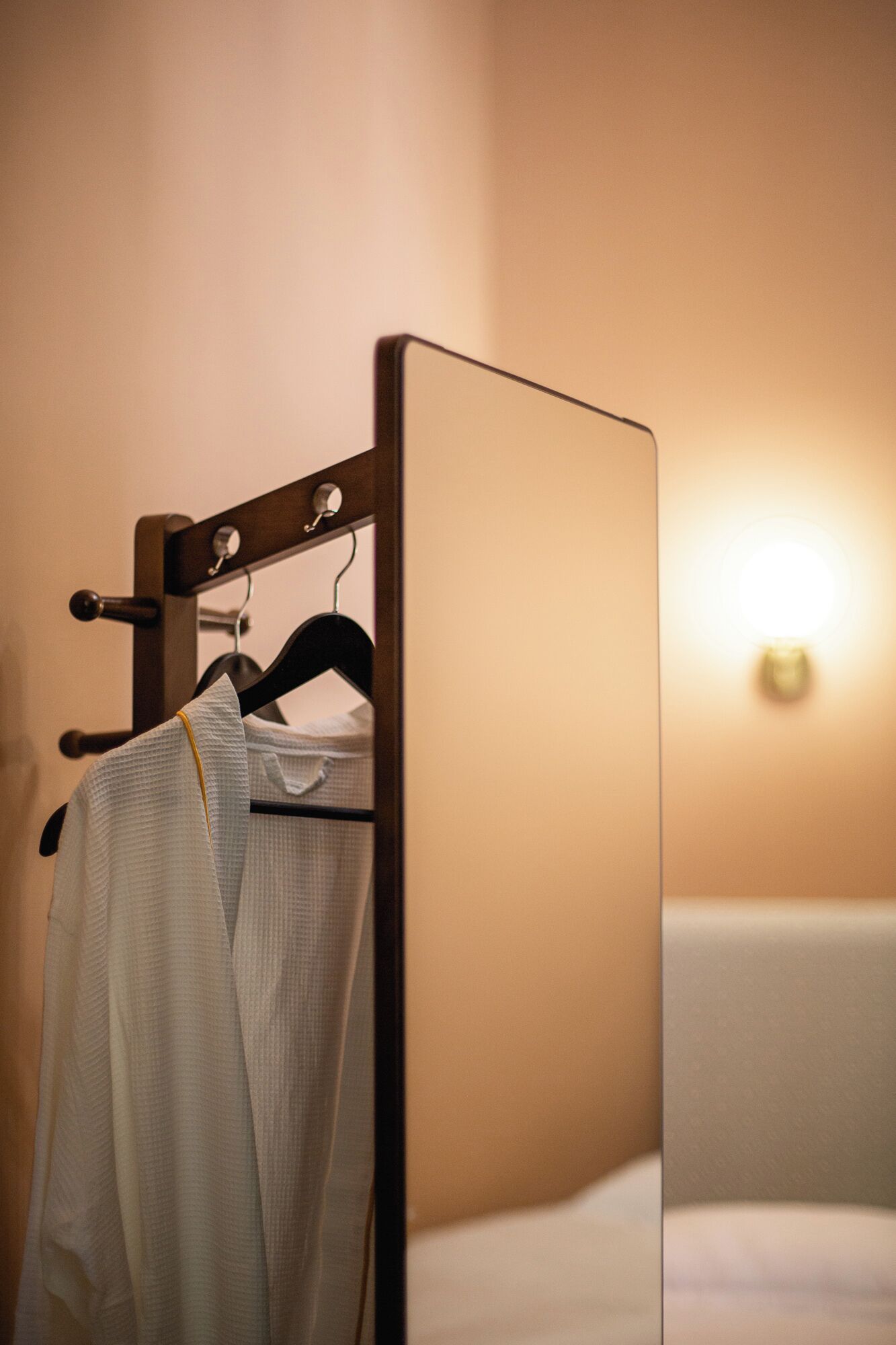 A compact room with a bed, a small bedside table, and a wall-mounted wardrobe.
