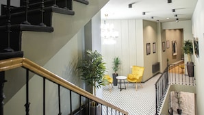 A multi-level interior with a staircase, a chandelier, and potted plants. - Boutique hotel tuta (Kutaisi)
