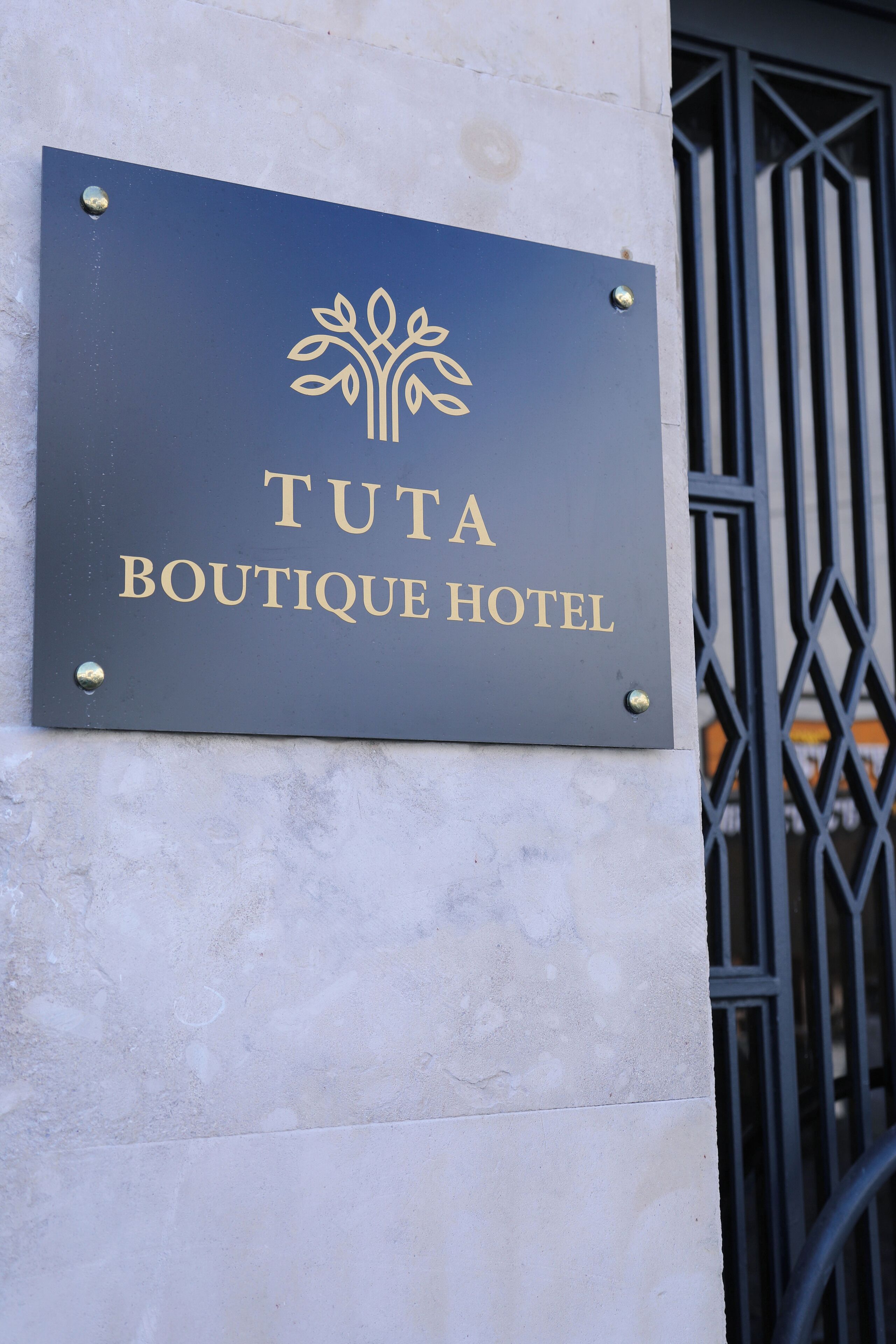 Señal para el Hotel Boutique Tuta, con un logo de árbol.