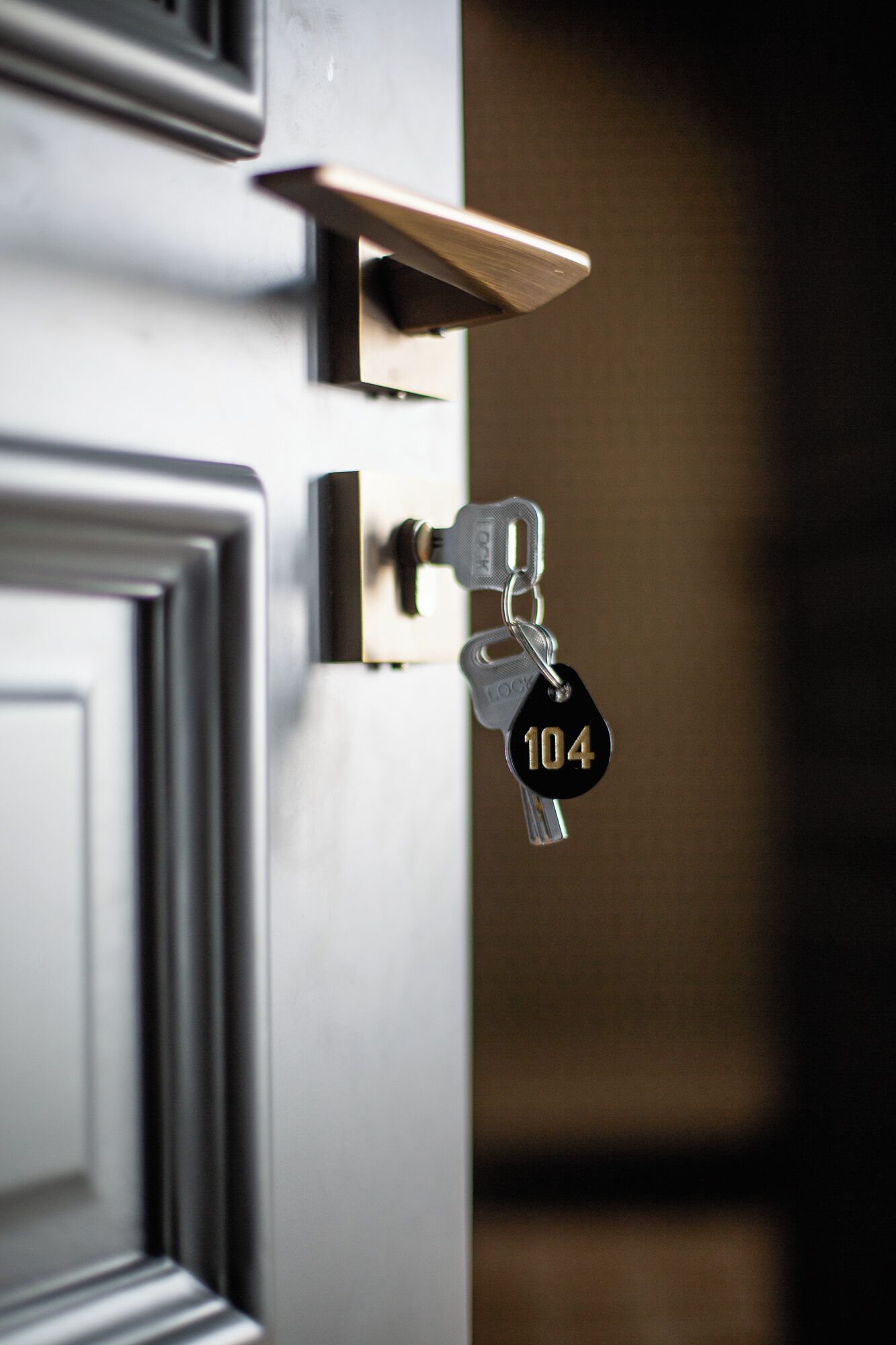 Una puerta con cerradura y una llave marcada con el número 104 insertada.