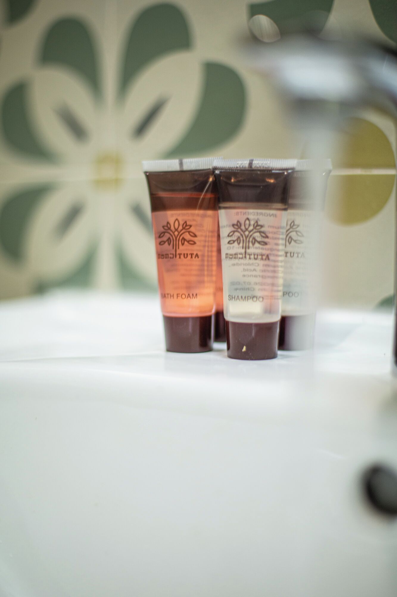 Three toiletry bottles labeled 'Tuta' on a white surface.