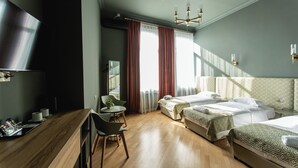 A modern hotel room with a wooden floor, a bed with patterned bedding, a desk with a chair, and a large mirror. - Boutique hotel tuta (Kutaisi)