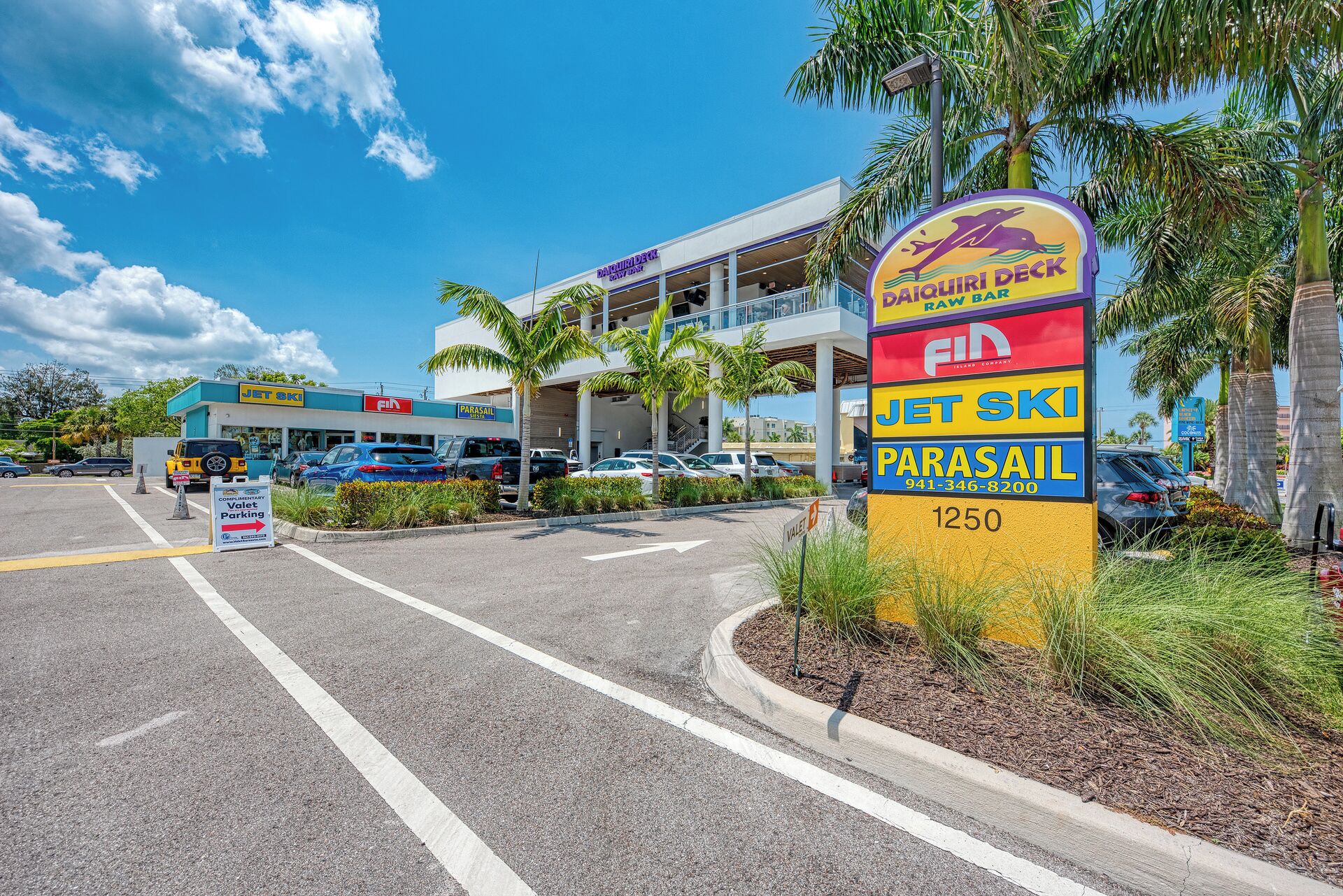 A parking lot with a sign for the Daiquiri Deck, Jet Ski, and Parasail rental services.