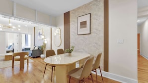 Un comedor moderno con una mesa de mármol, sillas de madera y un espejo grande.