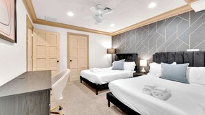 A hotel room with two beds, a desk, and a ceiling fan. - Prime 5BR Home Retreat | Sleeps 16 | South St Pier (Philadelphia)