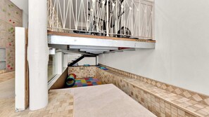 Ein Mehrbettzimmer mit Stockbett, einer Kletterwand und einer kleinen Spielecke mit einer bunten Matte.