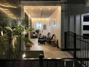 A well-lit indoor space with a seating area, a potted plant, and a staircase leading to an upper level. - Stunning Custom Built Home Near Boardwalk! (Carolina Beach)