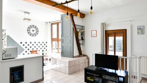 Un salon moderne avec un téléviseur, une horloge et une bibliothèque.