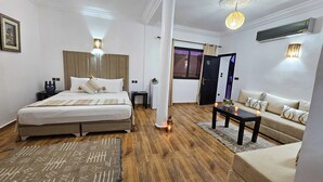 Een hotelkamer met een bed, een bank, een salontafel en een nachtkastje.