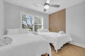 A hotel room with two beds, a ceiling fan, and a large window with blinds. - Modern Stay | Luxe 3BR | Sleeps 10 | 2 Min DT (Spartanburg)