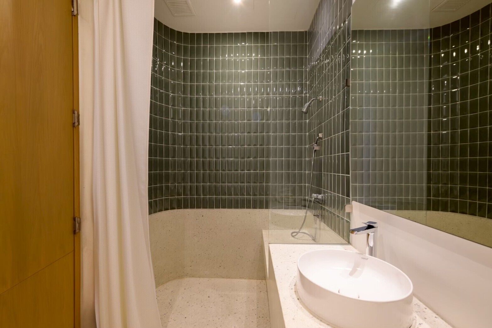 A modern bathroom with a freestanding bathtub, a round sink, and a glass shower enclosure.