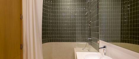 A modern bathroom with a freestanding bathtub, a round sink, and a glass shower enclosure.
