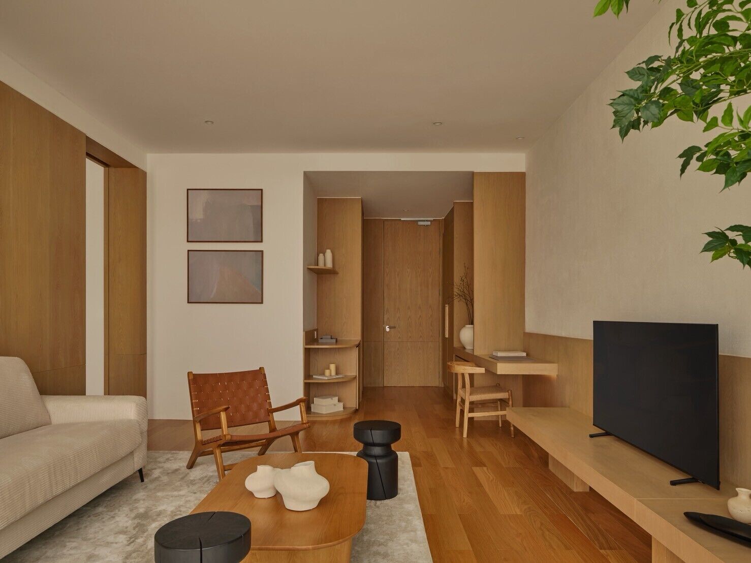 Una sala de estar moderna con un sofá, una mesa de centro, un televisor y una estantería.