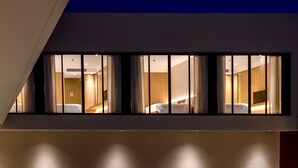 Une chambre d’hôtel moderne dotée d’une grande fenêtre, d’un lit et d’un téléviseur.