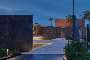 Una estructura arquitectónica moderna con paredes de hormigón y una fuente de agua.