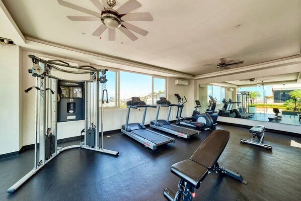 A gym with treadmills, a bench, and weight machines.