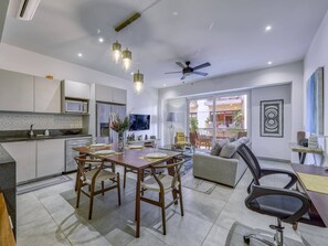 Una cocina moderna con comedor, ventilador de techo y vistas al exterior.