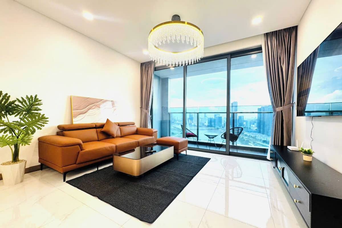 Ein modernes Wohnzimmer mit einer Couch, einem Couchtisch und einem großen Fenster mit Blick auf die Stadt.
