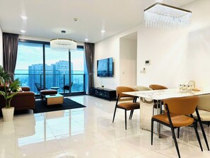 Deluxe Apartment, 3 Bedrooms, City View | Living area | 100-inch LED TV with cable channels