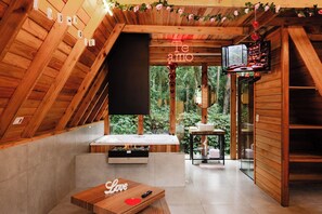 Un intérieur chaleureux en bois, avec une cheminée, un téléviseur et une pancarte sur laquelle on peut lire : « Te amo ».