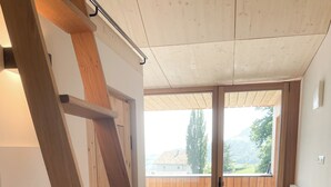 A wooden staircase leading to a balcony with a view of the countryside. - Apartment Schwarzhorn (Barbian)