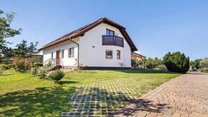 Une maison à deux étages dotée d’un balcon, d’une allée pavée et d’une pelouse bien entretenue.
