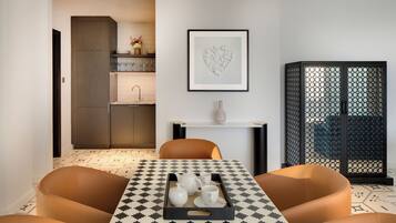 A modern dining area with a checkered tablecloth, a tray with tea set, and a decorative heart art piece on the wall.