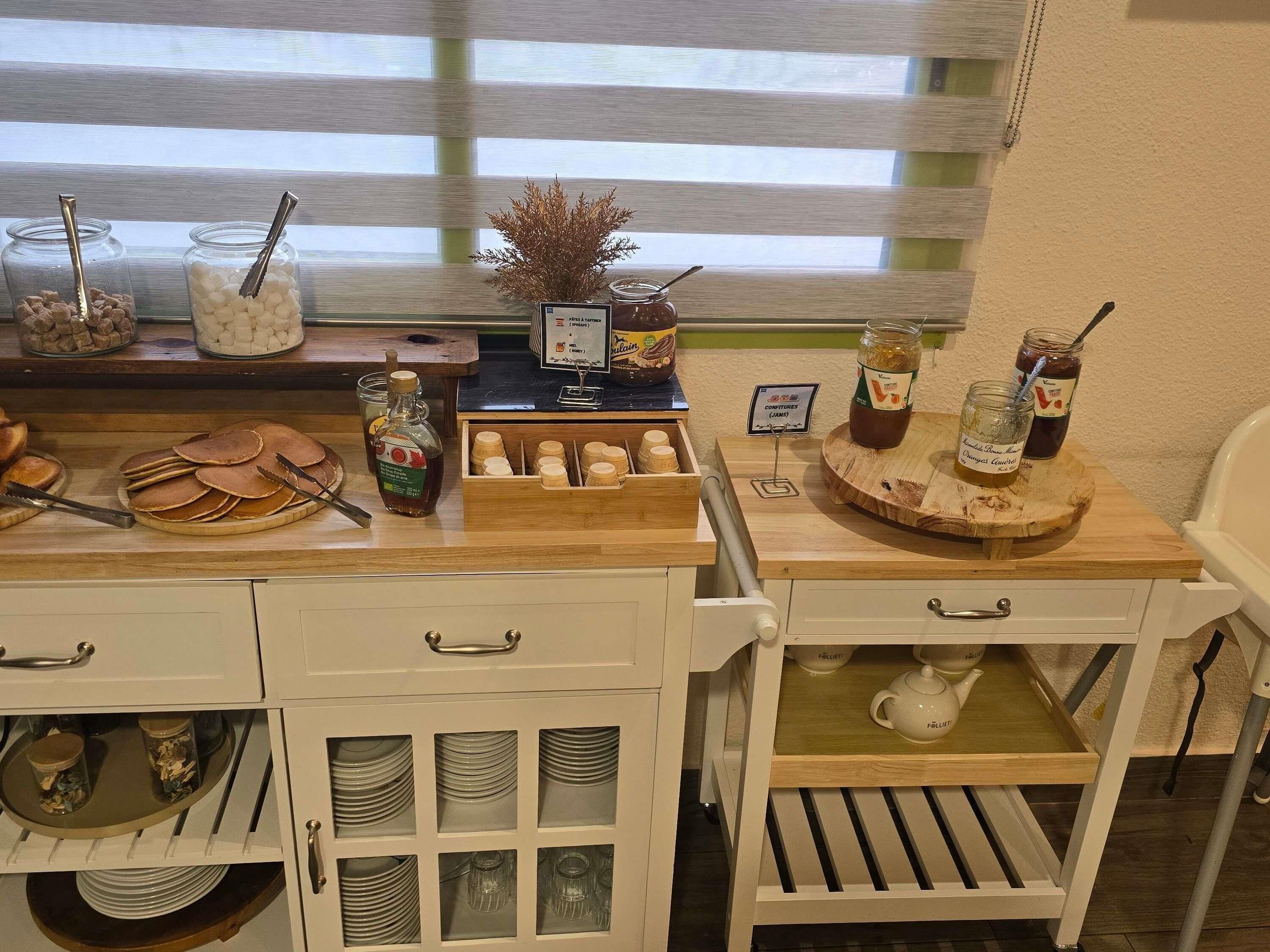 A breakfast buffet setup with various food items and condiments.