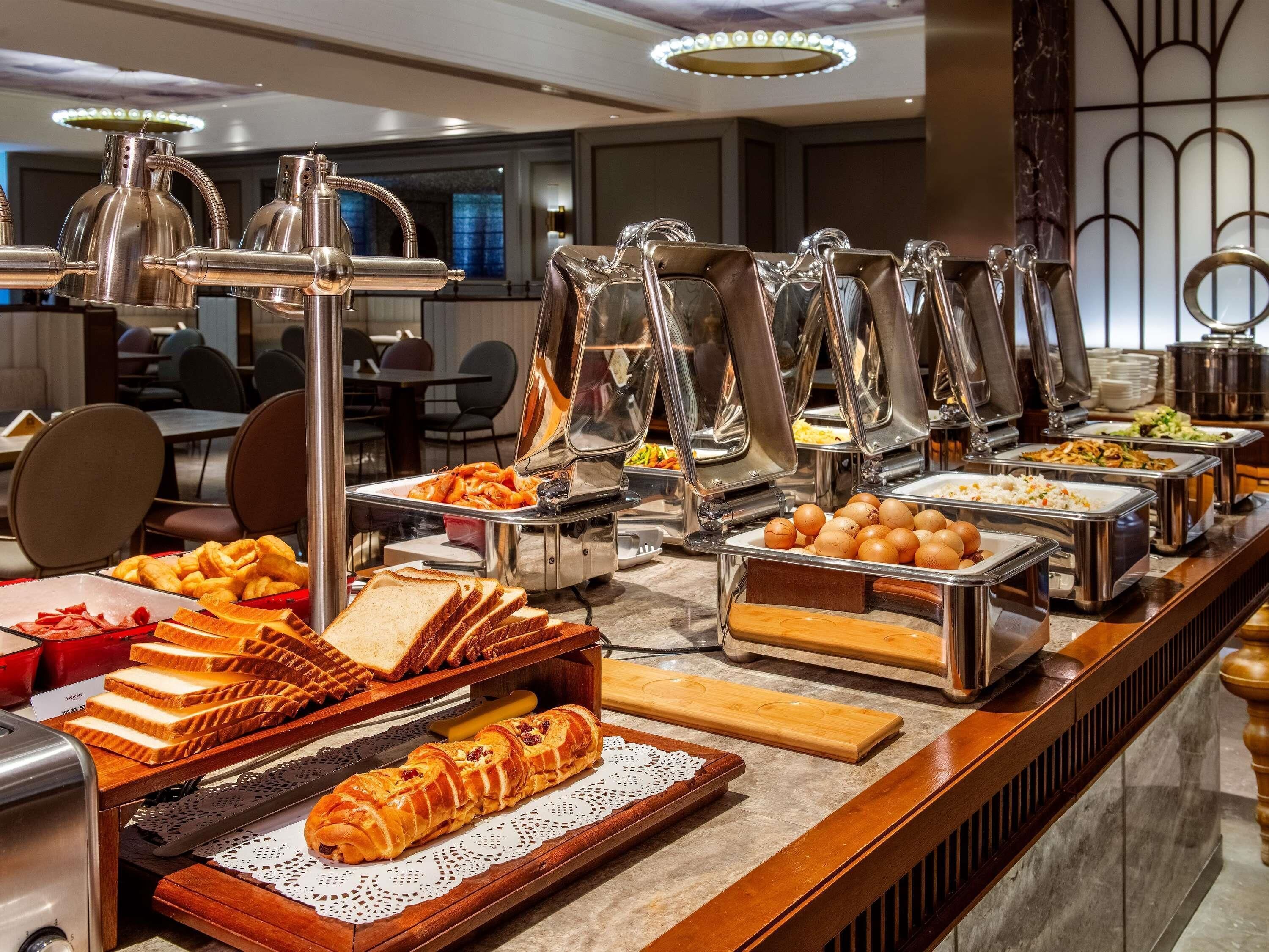 A buffet with various food items, including bread, eggs, and other breakfast foods.