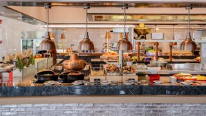 Montaje de bufé con diversos alimentos, equipo de cocina y frascos decorativos.