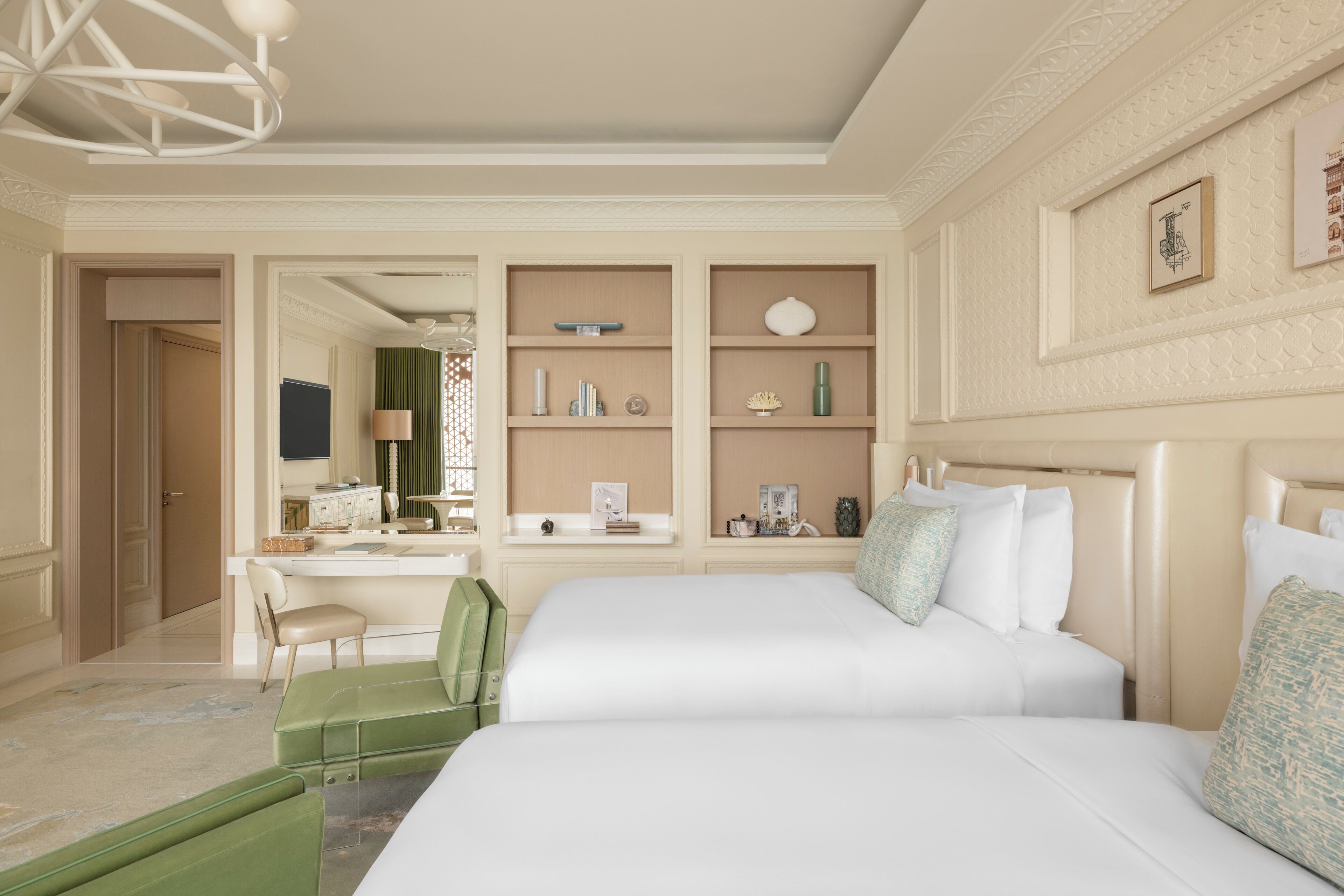 A hotel room with two beds, a desk, and a chair.