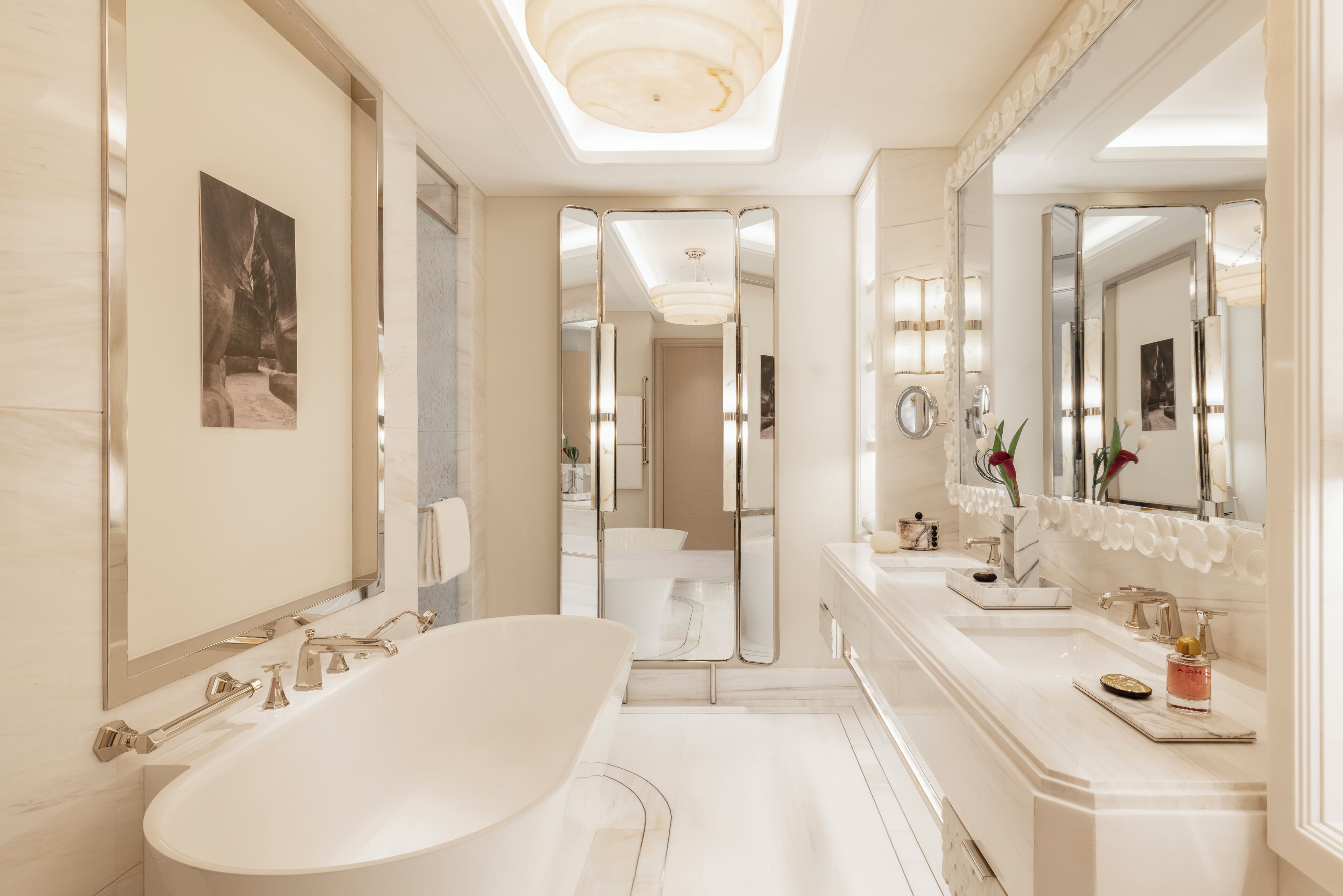 Une salle de bain moderne avec une baignoire sur pieds, un grand miroir et un meuble-lavabo doté d’un évier et d’un plan de travail.