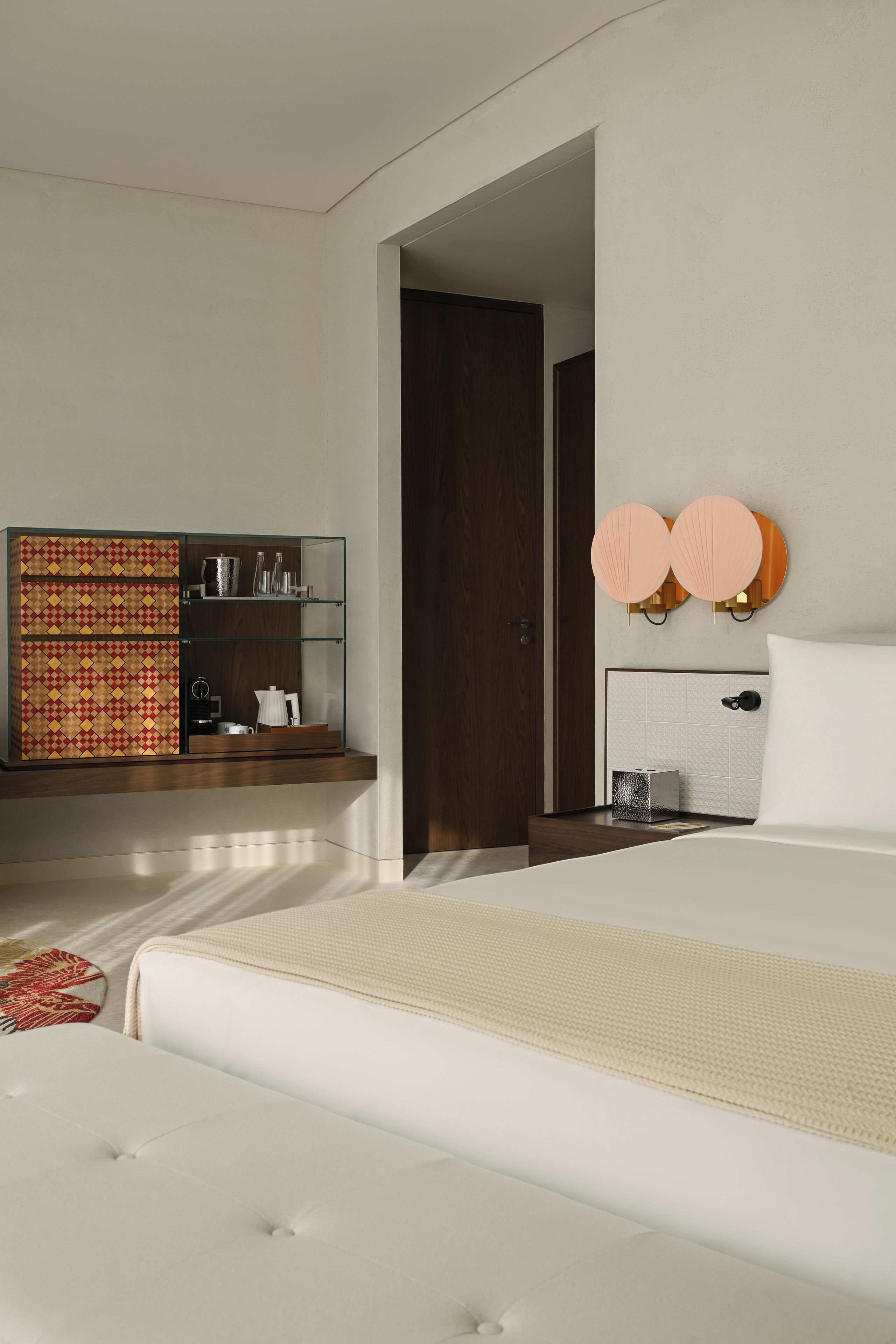 Un dormitorio moderno con una cama grande, un armario empotrado y una mesita de noche con una lámpara.