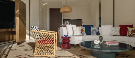 A modern living room with a sofa, a glass coffee table, and a wicker chair.
