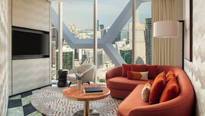 Ein modernes Wohnzimmer mit Blick auf die Stadt, inklusive Sofa, Couchtisch und Fernseher.