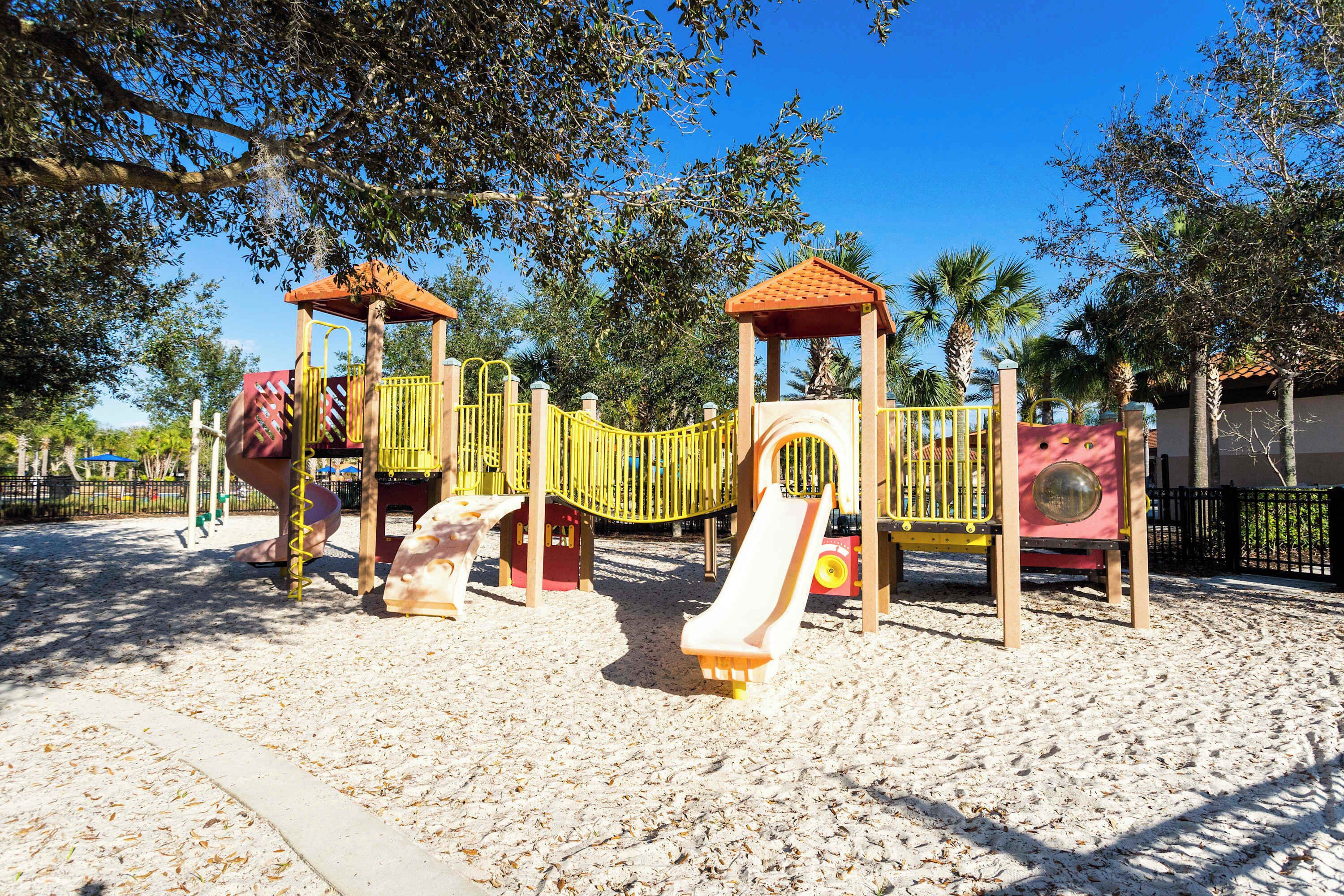 A playground with a slide, climbing structures, and a covered area.