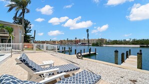 A waterfront hotel with lounge chairs, a dock, and a clear view of the water. - Oasis by the water. (Sarasota)