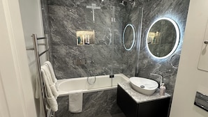 Ein modernes Badezimmer mit einer Badewanne, einem Waschbecken und einer Toilette.