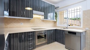 A modern kitchen with dark cabinetry, a built-in oven, a dishwasher, and a window with a view of greenery. - Tenohomes Ocean Light (Buenavista del Norte)
