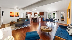 A spacious living area with a sofa, ottoman, and coffee table, a kitchen with bar stools, and a dining area with chairs. - 30% Off September Perfect 4 Families Pool, Jacuzzi (Palm Springs)