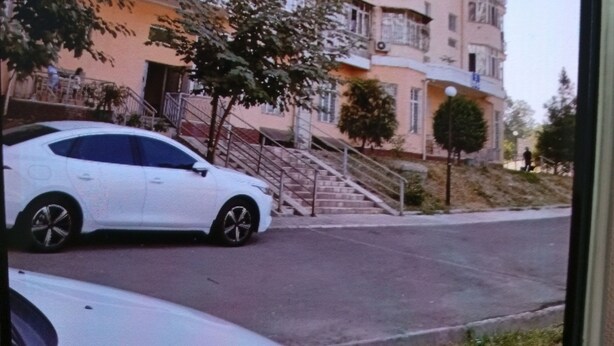 A multi-story residential building with a central staircase leading to the entrance.