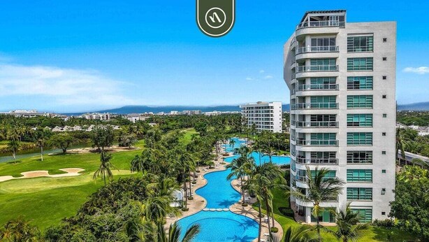 Ein modernes Hotel mit Poolbereich, umgeben von üppiger Vegetation und einem Golfplatz.